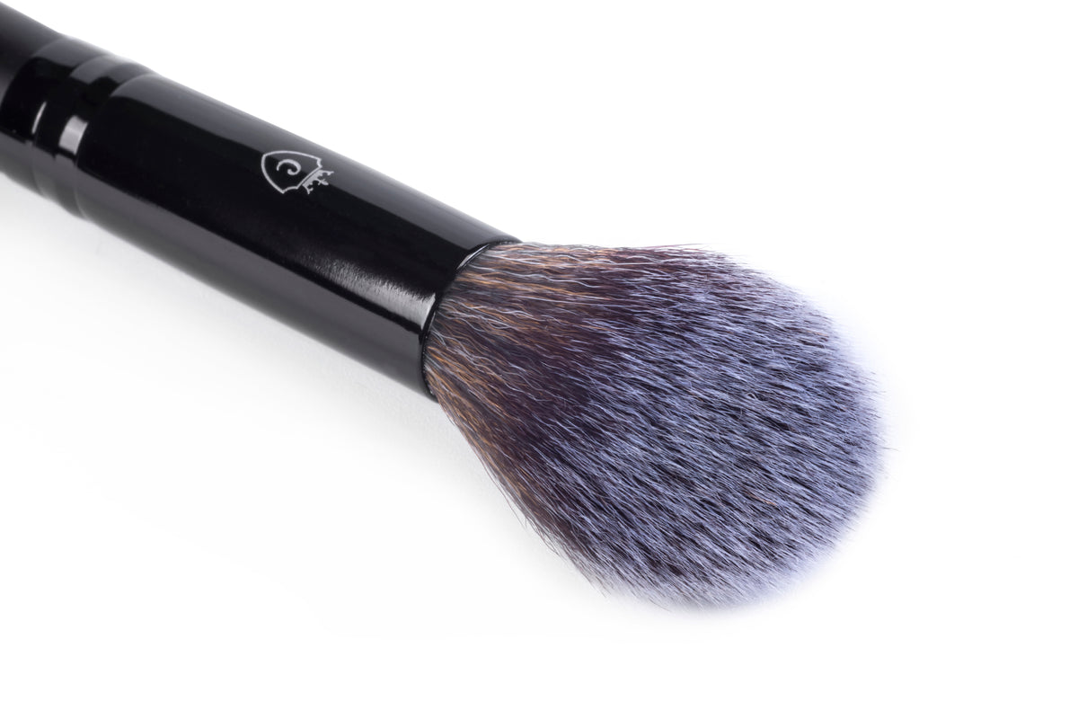 Single makeup brush with a black handle and soft, rounded purple and brown bristles.