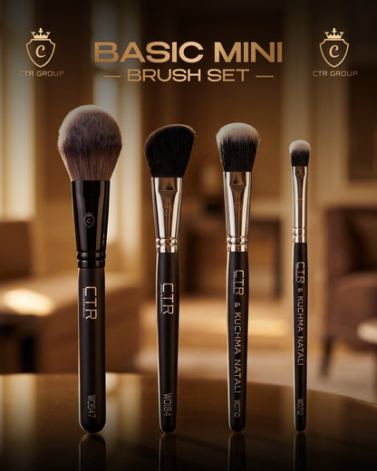 A set of five black makeup brushes with silver ferrules and white branding, displayed on a reflective dark surface against a warm blurred background. Text at the top reads 'BASIC MINI BRUSH SET' with CTR Group logos on both sides.