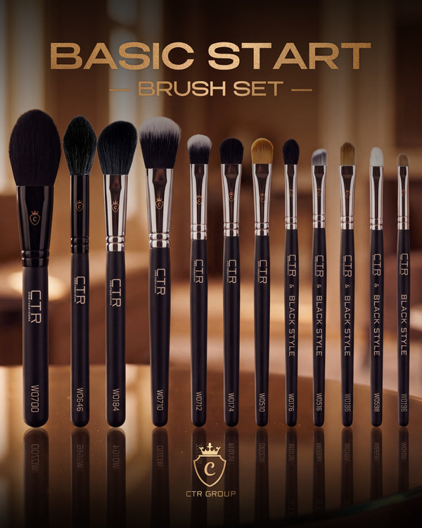 Twelve black CTR makeup brushes with silver ferrules and various bristle shapes standing in a row on a reflective surface.